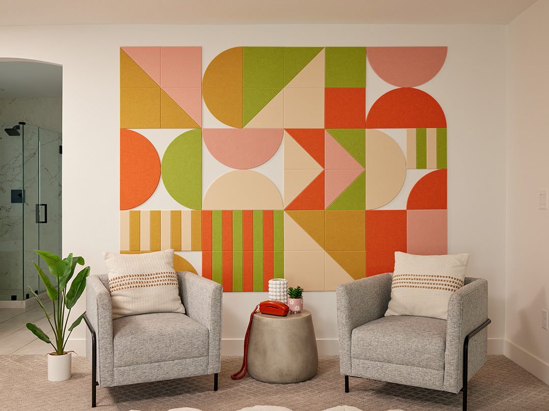 Modern living room with geometric felt wall art, two gray chairs, and a small table.