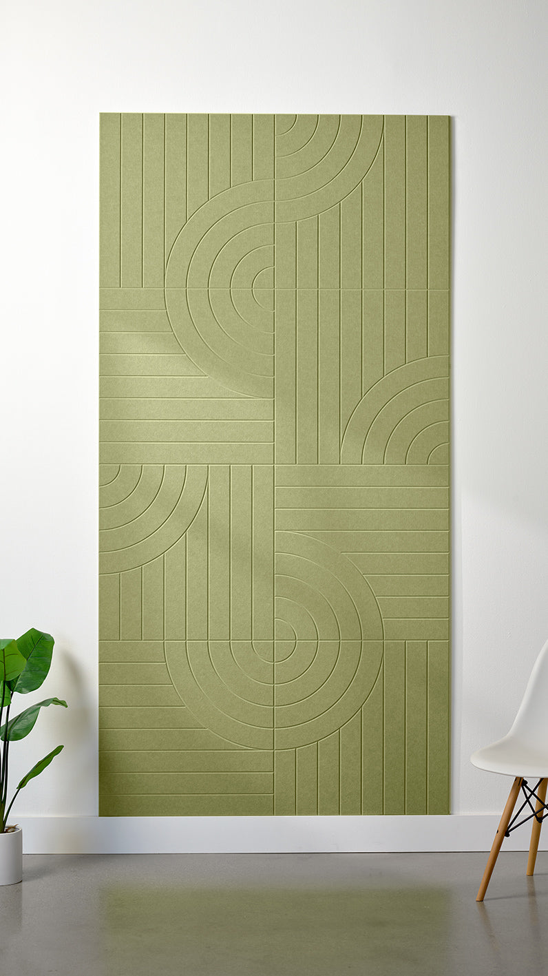 Aloe green Felt Right 4’ x 8’ PET felt panel with straight and circular lines engraved into the material against a white wall. A plant and chair are in the foreground.