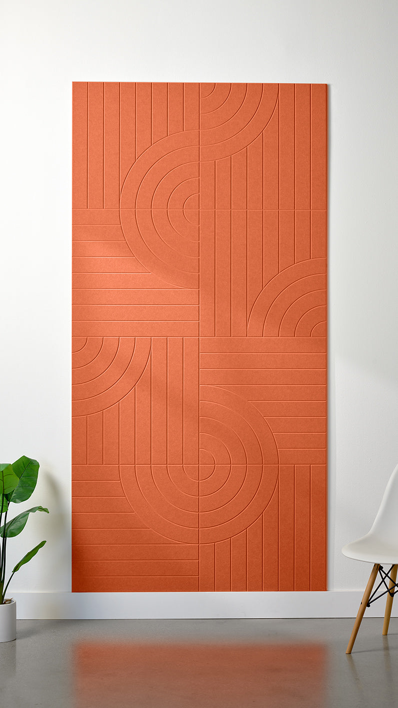 Orange Felt Right 4’ x 8’ PET felt panel with straight and circular lines engraved into the material against a white wall. A plant and chair are in the foreground.
