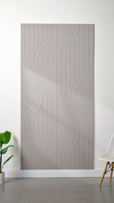 Light grey Felt Right 4’ x 8’ PET felt panel with straight and circular lines engraved into the material against a white wall. A plant and chair are in the foreground.