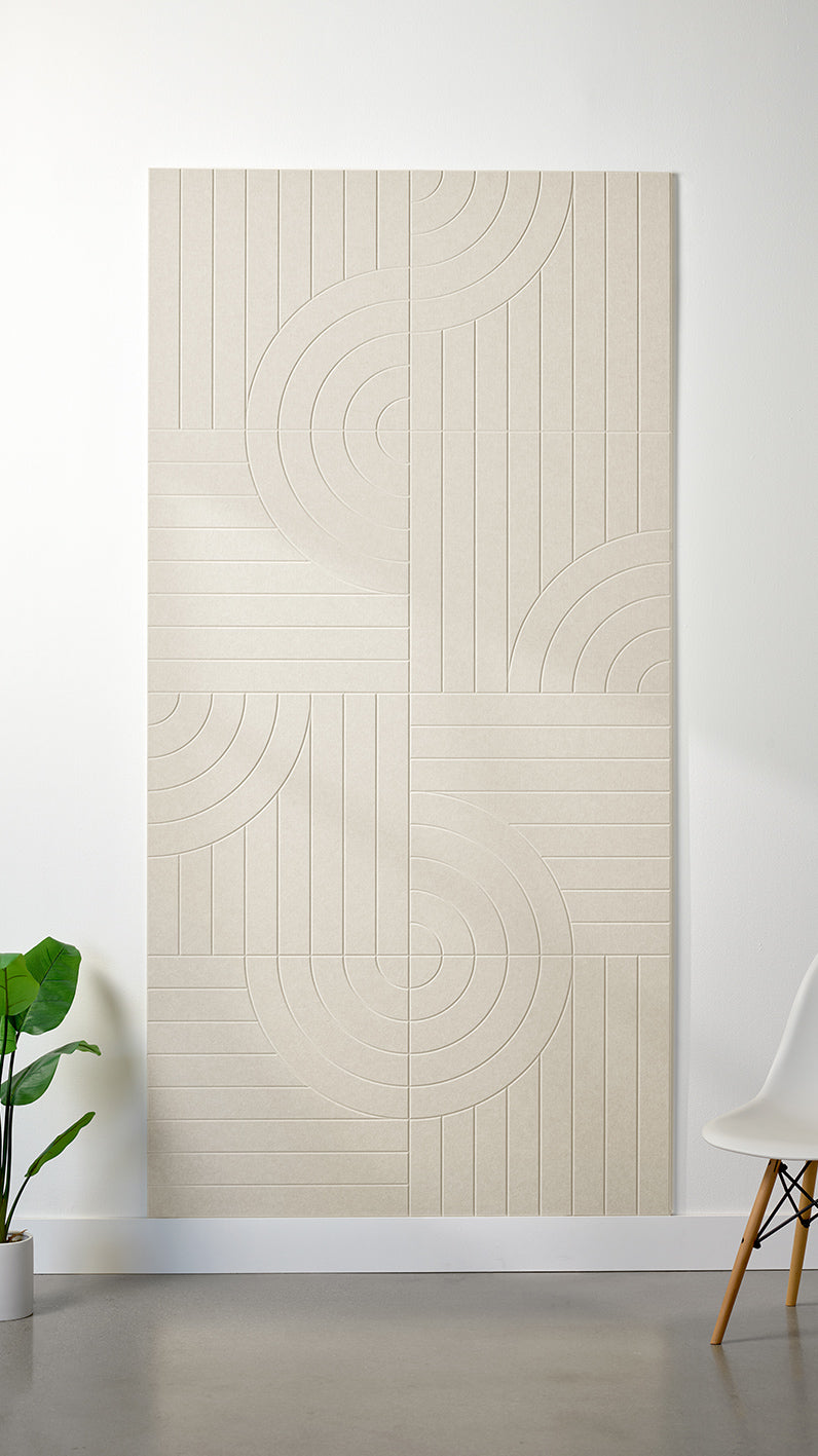 Ivory Felt Right 4’ x 8’ PET felt panel with straight and circular lines engraved into the material against a white wall. A plant and chair are in the foreground.