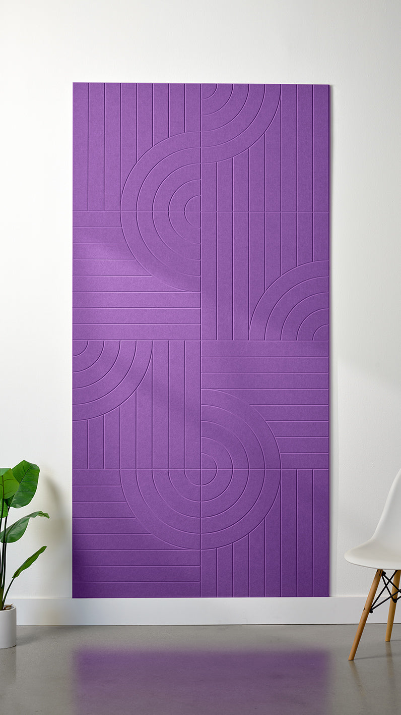 Lavender Felt Right 4’ x 8’ PET felt panel with straight and circular lines engraved into the material against a white wall. A plant and chair are in the foreground.