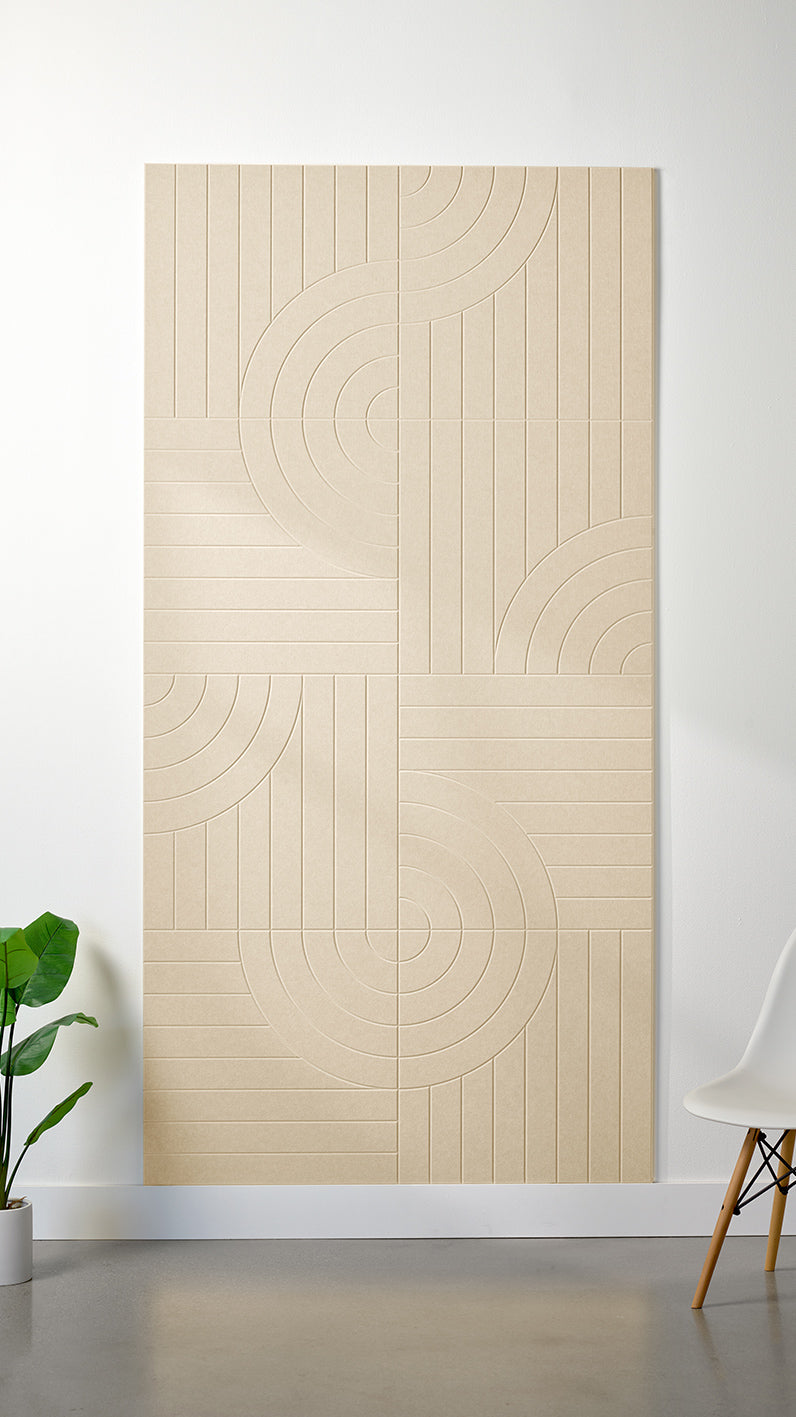 Beige Felt Right 4’ x 8’ PET felt panel with straight and circular lines engraved into the material against a white wall. A plant and chair are in the foreground.