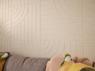 Beige wall with circular pattern next to a bed with colorful bedding