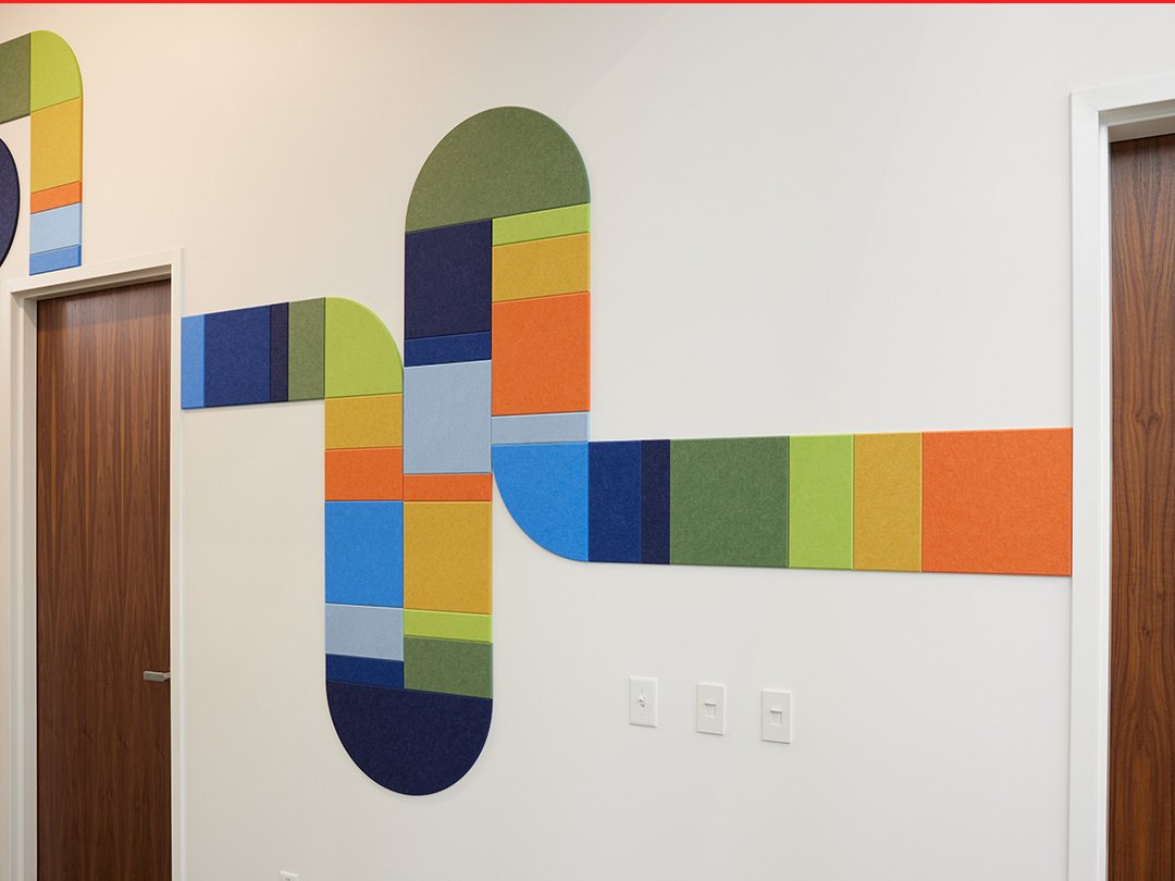 felt right wall art design in multicolors creating a pipe-like design going down a hallway with doors 