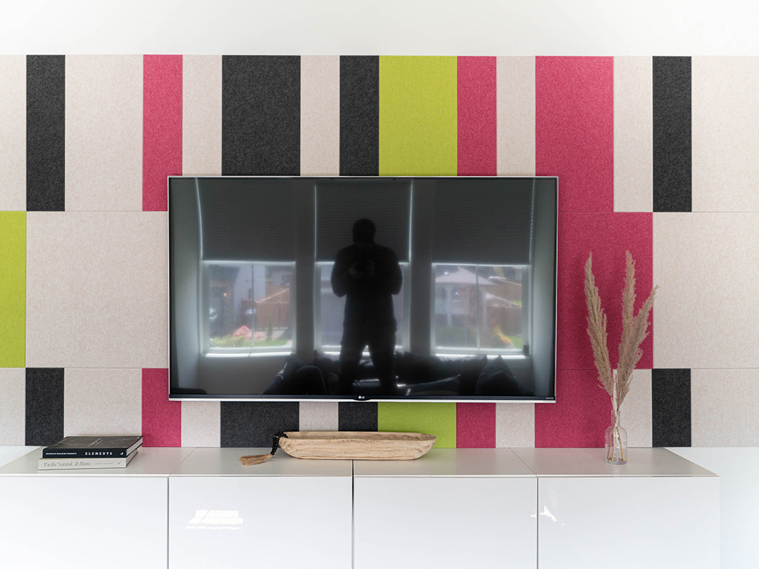 Pink and green wall art behind Tv