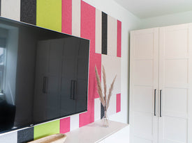 Pink and green wall art behind Tv