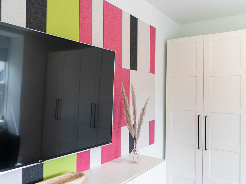 Pink and green wall art behind Tv