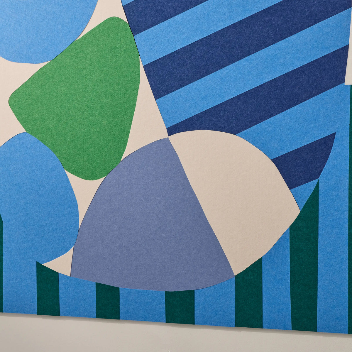 Abstract geometric wall art featuring overlapping organic shapes and striped blocks in blue, navy, green, and cream tones.