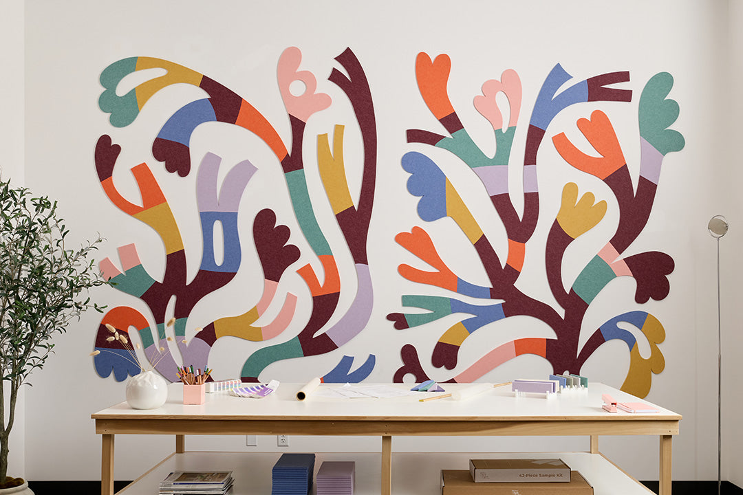 Colorful abstract wall mural in a room with a wooden table and decor items.