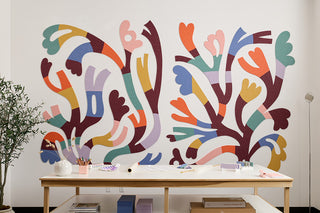 Colorful abstract wall mural in a room with a wooden table and decor items.