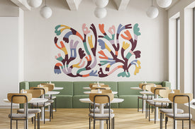 Modern restaurant interior with colorful wall art and green booth seating.