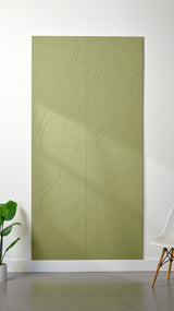 Aloe green Felt Right 4’ x 8’ PET felt panel with flowing lines similar to a topographical map engraved into the material against a white wall. A plant and chair are in the foreground.