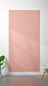 Light pink Felt Right 4’ x 8’ PET felt panel with flowing lines similar to a topographical map engraved into the material against a white wall. A plant and chair are in the foreground.