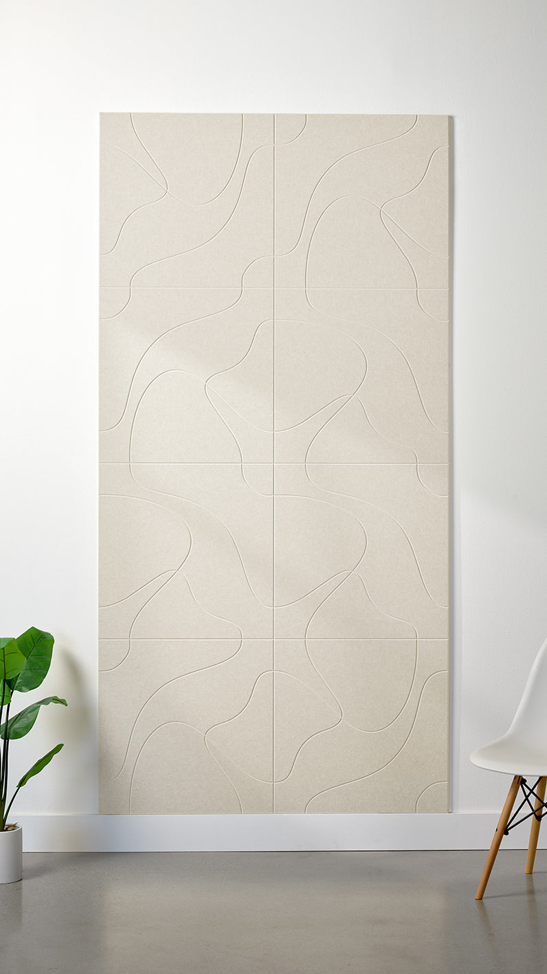 Ivory Felt Right 4’ x 8’ PET felt panel with flowing lines similar to a topographical map engraved into the material against a white wall. A plant and chair are in the foreground.