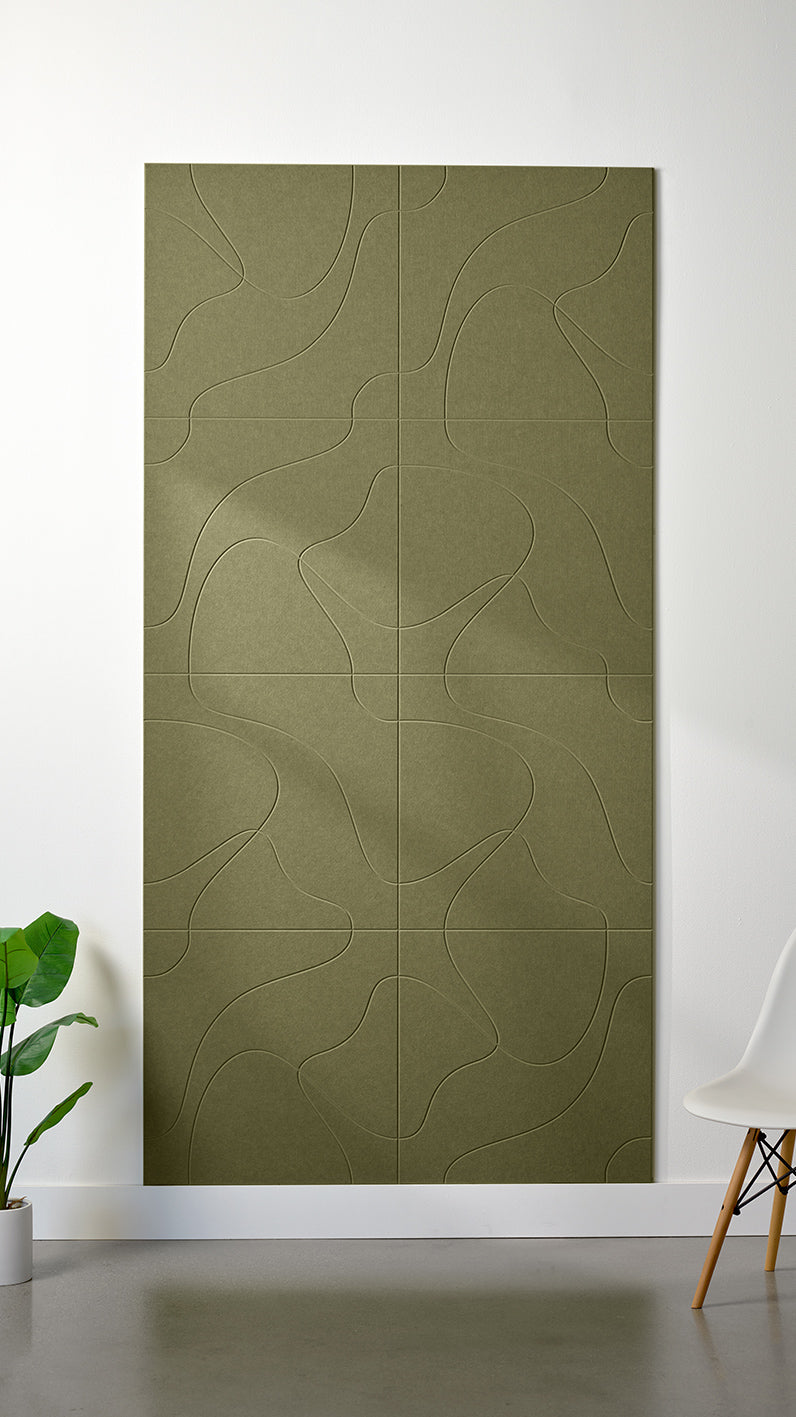 Olive green Felt Right 4’ x 8’ PET felt panel with flowing lines similar to a topographical map engraved into the material against a white wall. A plant and chair are in the foreground.