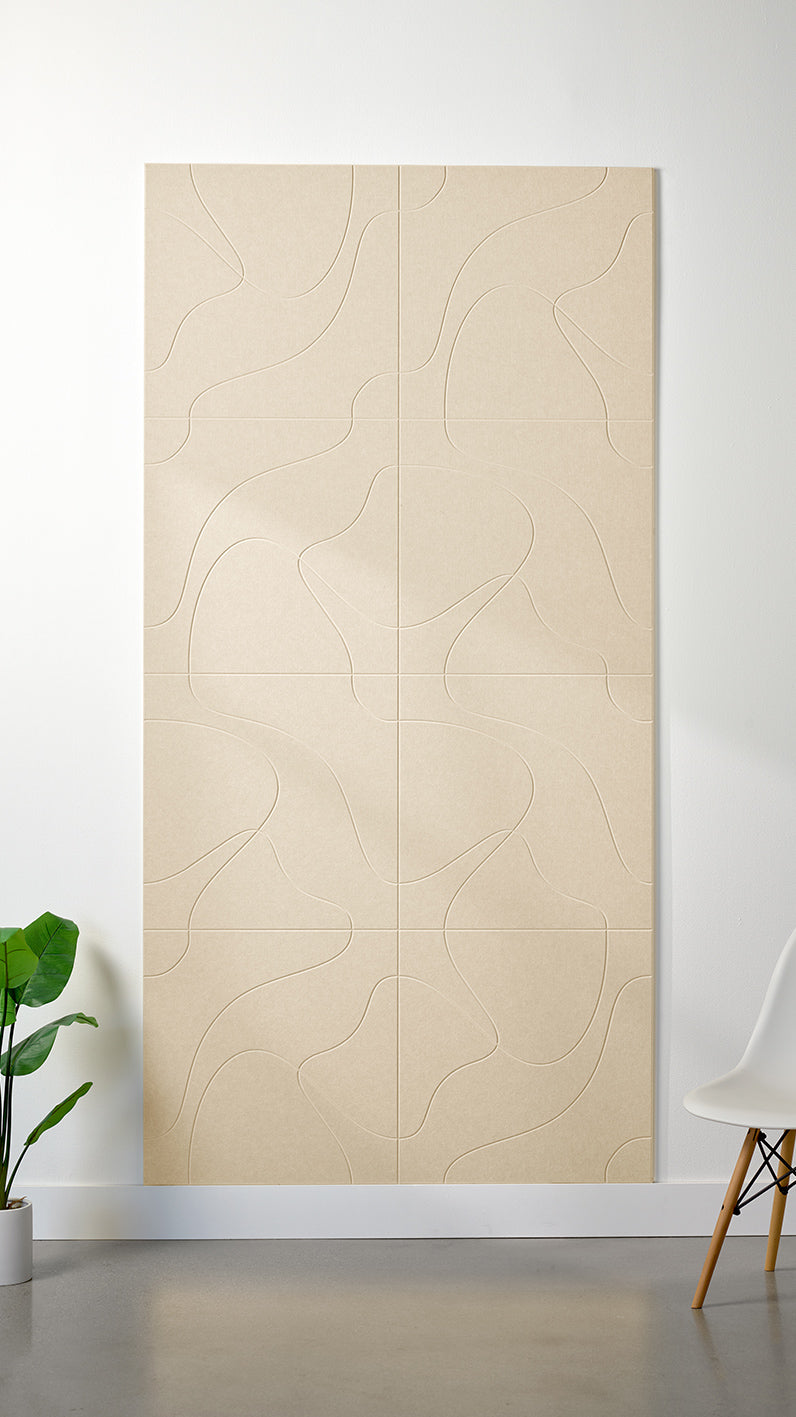 Beige Felt Right 4’ x 8’ PET felt panel with flowing lines similar to a topographical map engraved into the material against a white wall. A plant and chair are in the foreground.
