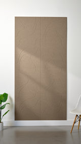 Light brown Felt Right 4’ x 8’ PET felt panel with flowing lines similar to a topographical map engraved into the material against a white wall. A plant and chair are in the foreground.