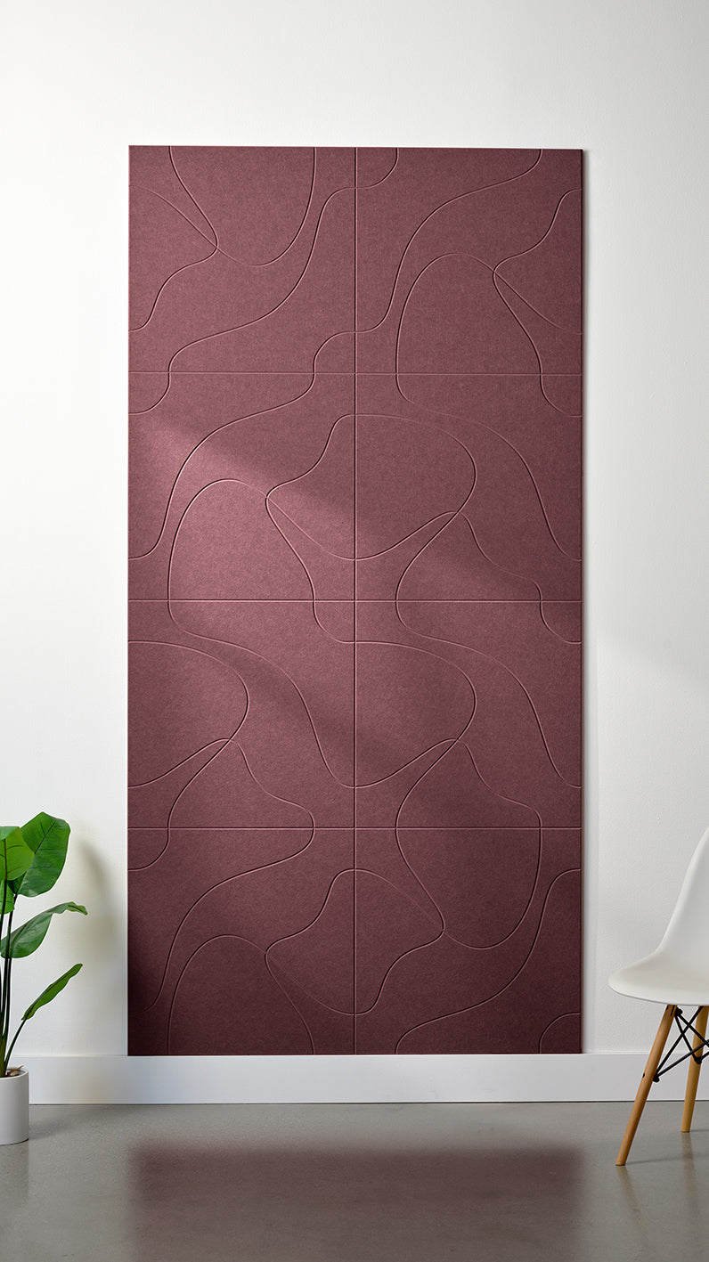 Maroon Felt Right 4’ x 8’ PET felt panel with flowing lines similar to a topographical map engraved into the material against a white wall. A plant and chair are in the foreground.