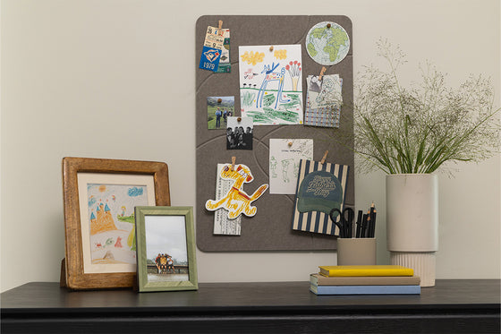 Home desk setup with a pinboard and frames.