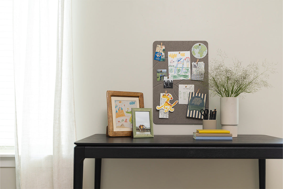 Home desk setup with a pinboard and frames.