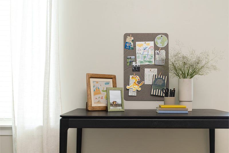 Home desk setup with a pinboard and frames.