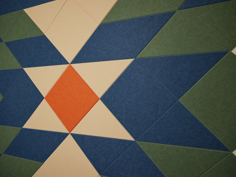 A Felt Right wall art design using shades of blue, green, cream, and orange triangle felt tiles.