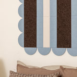 Textured wall with blue and brown striped pattern and pillows at the bottom.