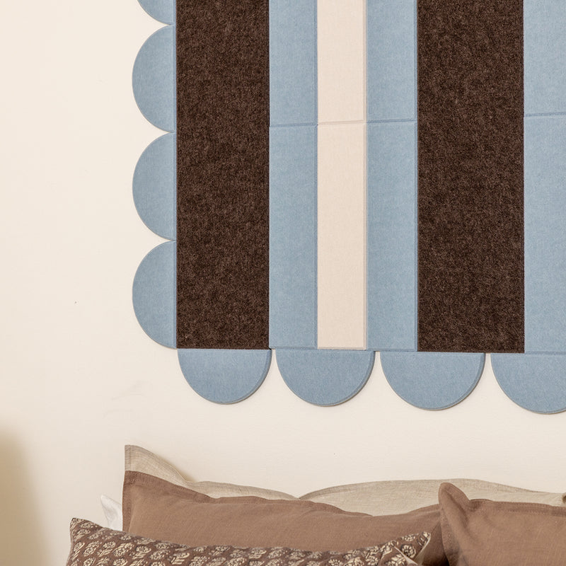 Textured wall with blue and brown striped pattern and pillows at the bottom.