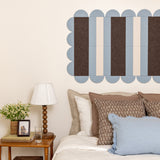 Decorative wall art above a bed with pillows and a lamp on a nightstand.