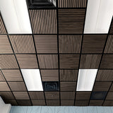 A ceiling grid of square acoustic tiles, featuring alternating dark brown wood-grain slatted panels and white rectangular panels, with black metal grout lines.