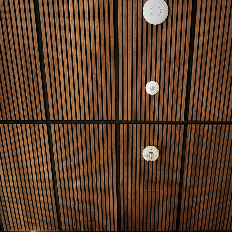 Wooden panel with circular cutouts and visible brand label