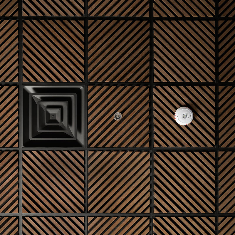 Close-up of a patterned floor with brown and black tiles.