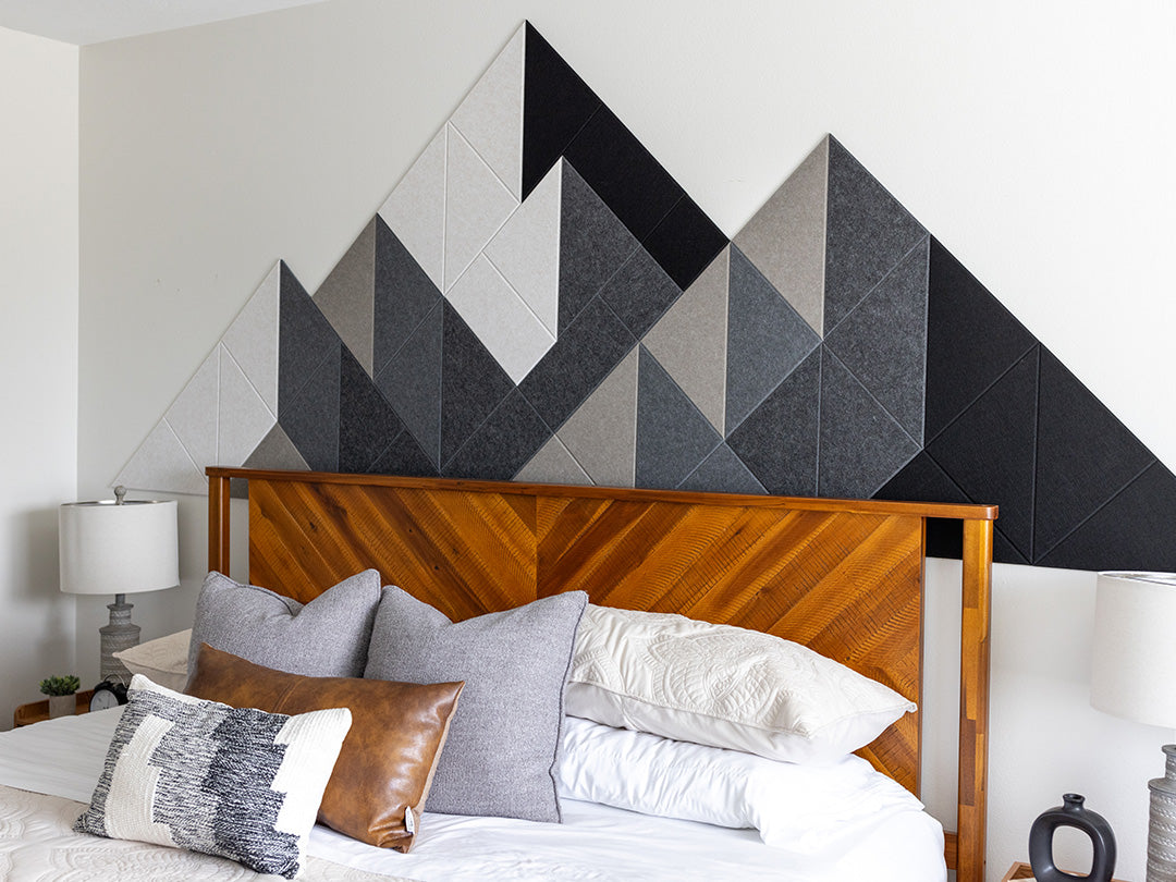 Warm Shaded Mountain Felt Right design above a wooden headboard and bed with white comforter and grey and brown pillows.