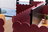 Red scalloped office partitions with computer monitors in a modern office setting.