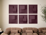 Six burgundy wall tiles with three-dimensional geometric cutouts arranged in a grid above a tan sofa.