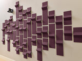 Purple three-dimensional tiles arranged in a scattered wall pattern with varying depths and angles.