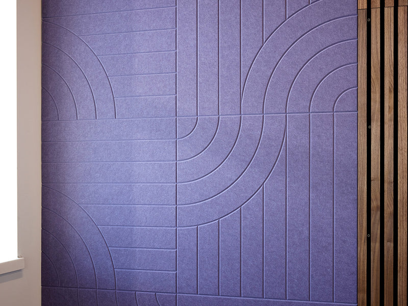 A Felt Right wall art design in a shade of purple with tangent lines next to wood paneling.