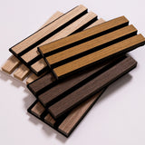 A stack of rectangular wood slats samples in multiple natural wood tones, including light tan, medium brown, and dark brown, arranged on a plain light background.