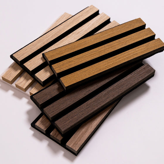 A stack of rectangular wood slats samples in multiple natural wood tones, including light tan, medium brown, and dark brown, arranged on a plain light background.