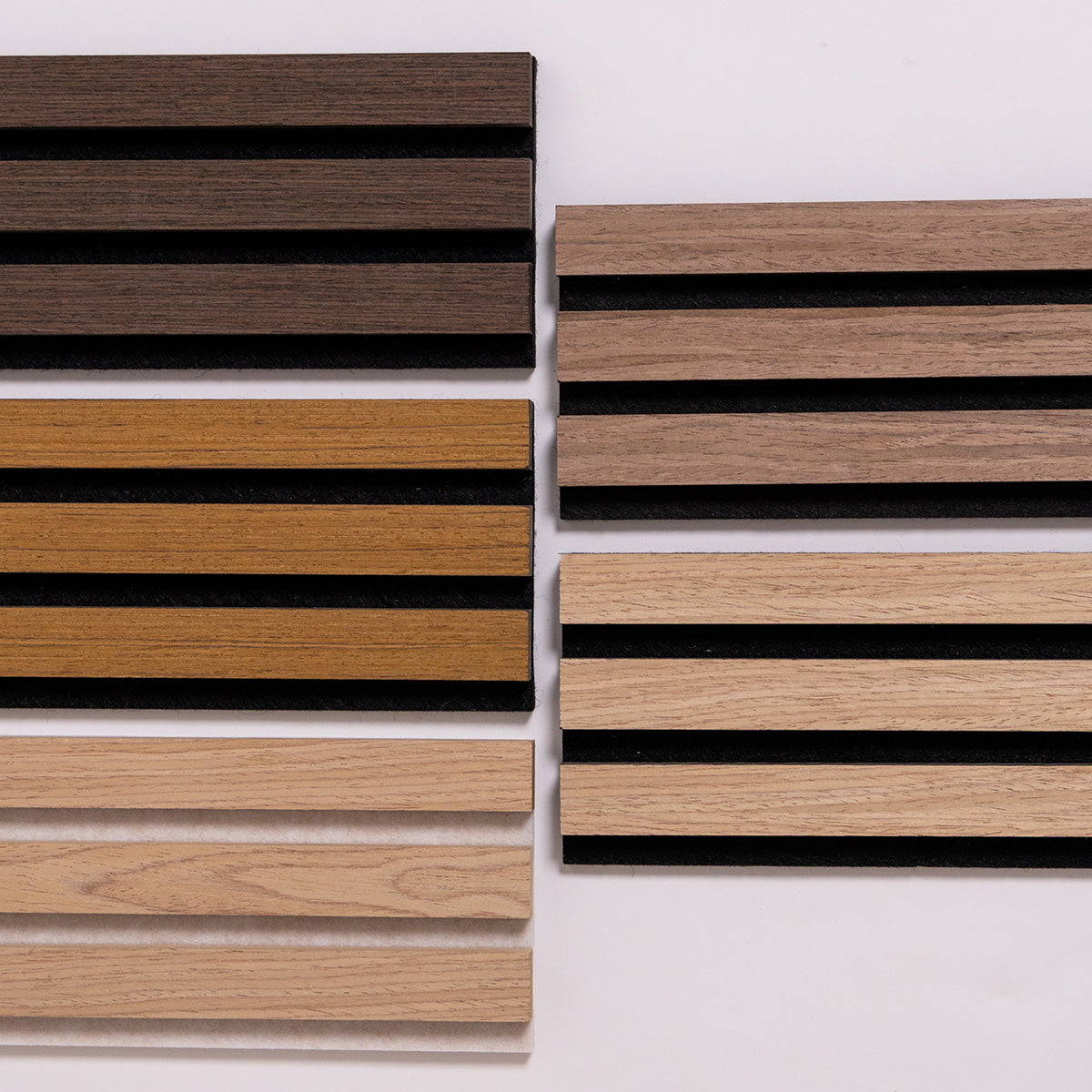 A flatlay of rectangular wood slats samples in multiple natural wood tones, including light tan, medium brown, and dark brown, arranged on a plain light background.