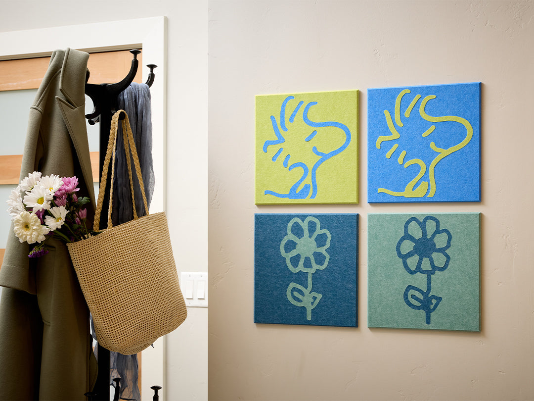 Decorative wall art with Woodstock Peanuts designs on a light-colored wall next to a coat and bag.