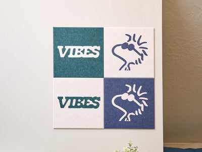 Decorative wall art with Peanuts Woodstock designs on a light-colored wall next to a coat and bag.