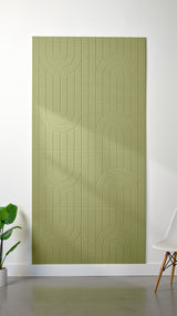 Aloe green Felt Right 4’ x 8’ PET felt panel with a linear and curvy pattern engraved into the material against a white wall. A plant and chair are in the foreground.