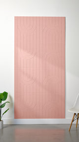 Light pink Felt Right 4’ x 8’ PET felt panel with a linear and curvy pattern engraved into the material against a white wall. A plant and chair are in the foreground.