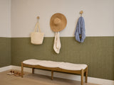 Olive green wainscoting with vertical ribbed texture covering lower half of white wall in room setting.