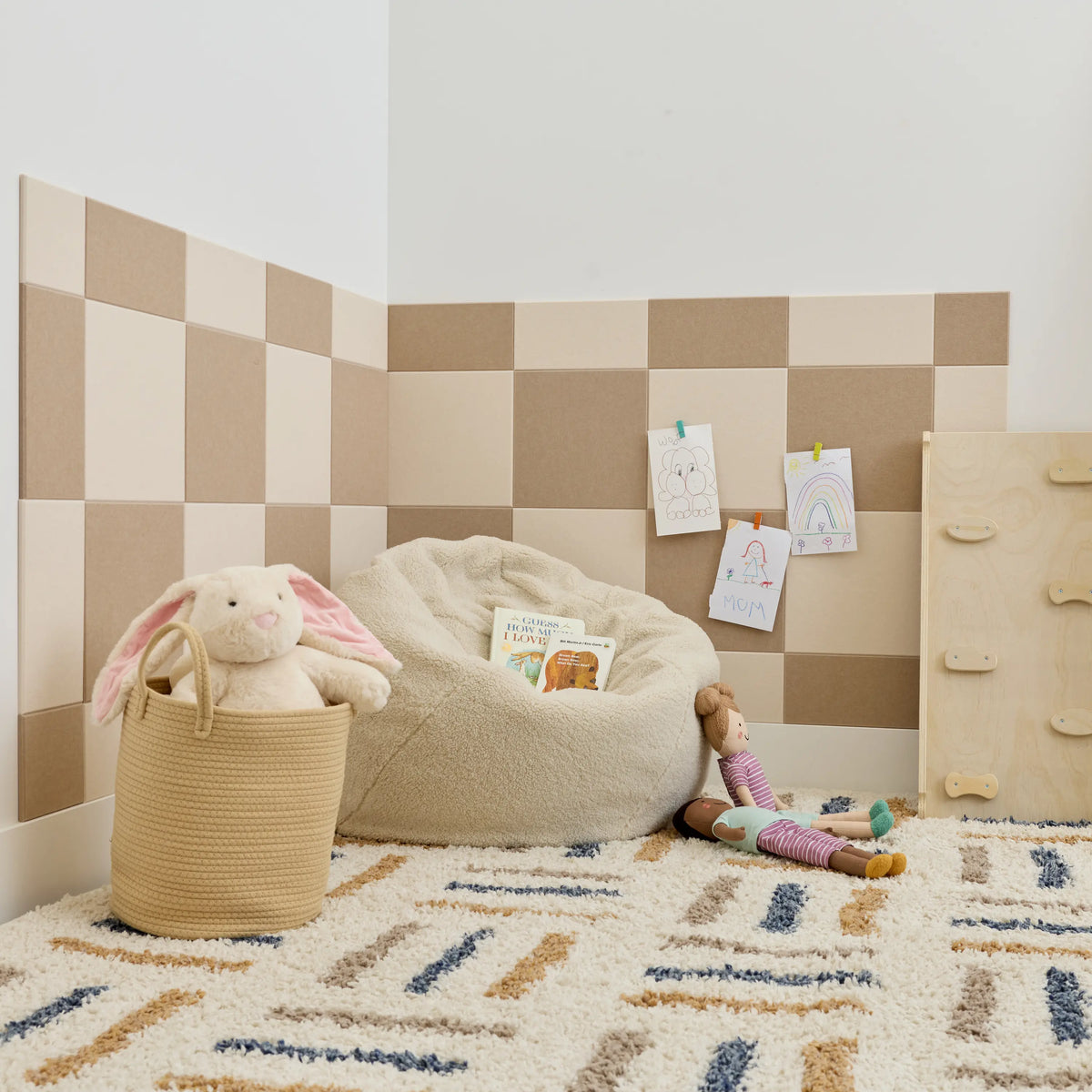 Cashmere and ivory checkerboard felt wall tiles in a playroom corner with a bean bag