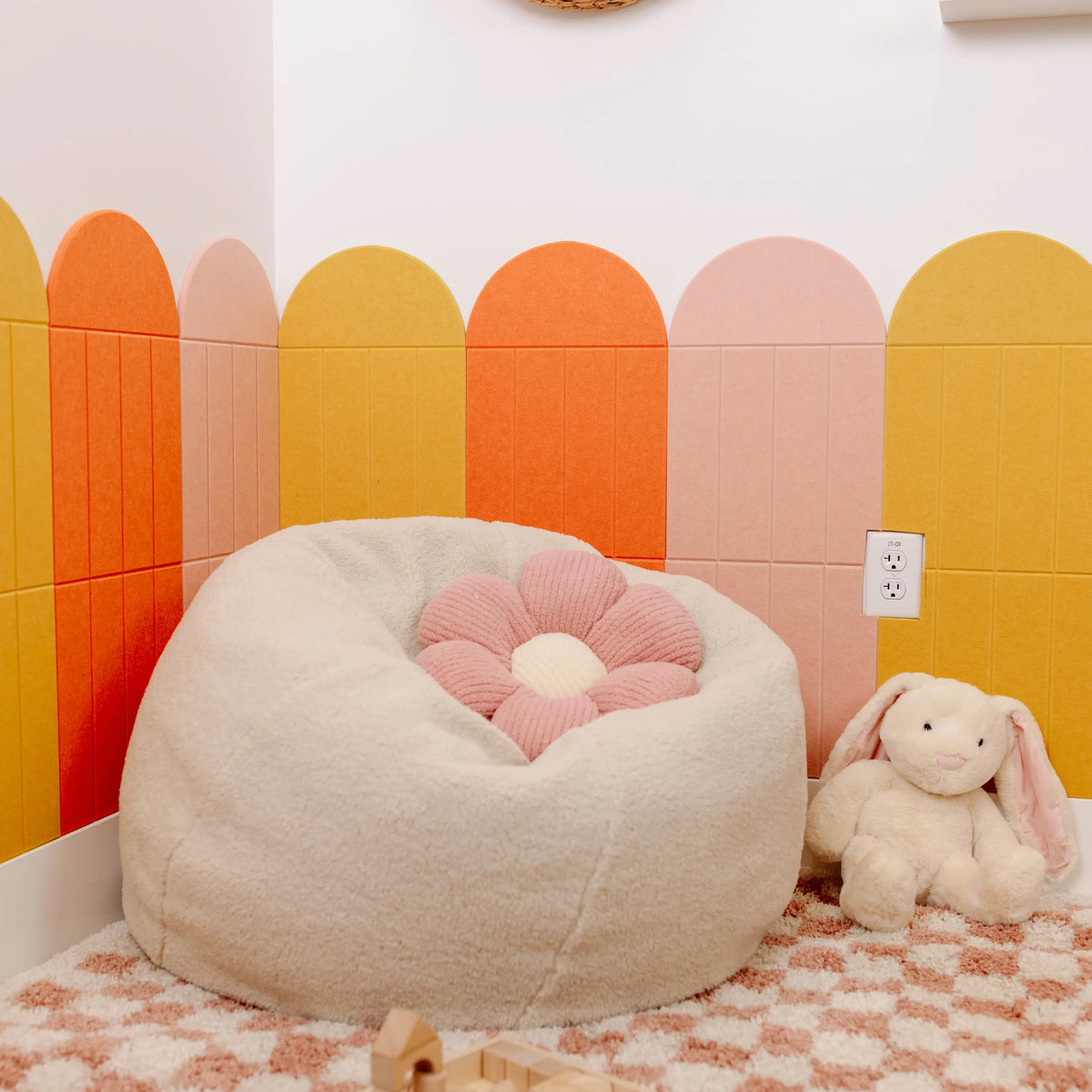 Coral, mustard and pink arch and scallop felt tiles in a playroom with a bean bag chair