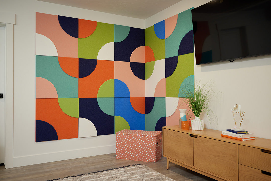 Modern room with colorful geometric acoustic wall art and wooden furniture.