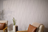 Light gray wallpaper with vertical wavy line pattern displayed on wall behind mid-century style furniture.